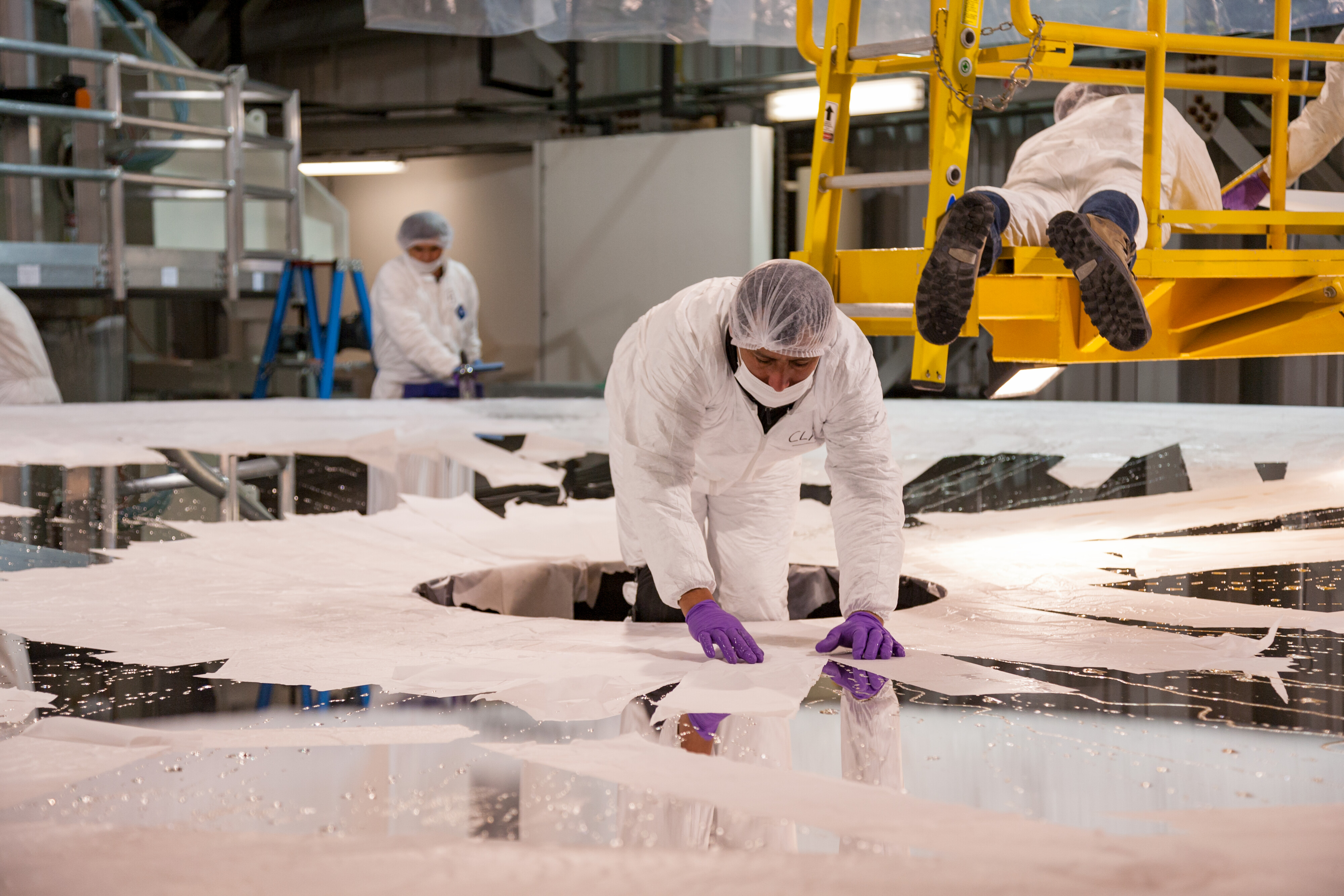 Local staff work at NOIRLab facilities in Chile; here staff prepare Gemini South's primary mirror for stripping prior to recoating in protective silver.