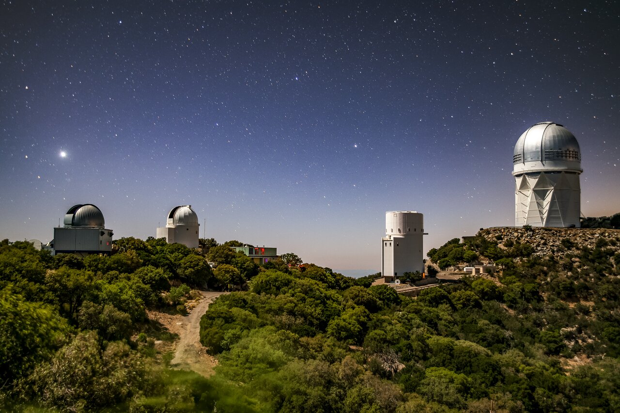 Moonlit night view showing both Spacewatch telescope domes open