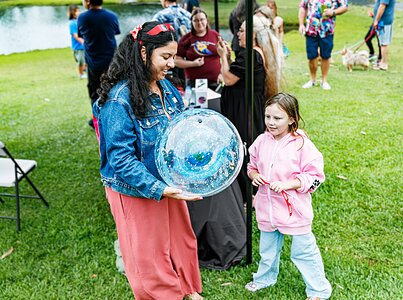 Una keiki (niña) en el evento ʻOhana Stargazing de Journey Through the Universe, aprende sobre las constelaciones y cómo parecen moverse alrededor de la Tierra con la Gerente de Educación y Vinculación con el Medio de Hawaiʻi, Leinani Lozi.