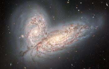 Interacting spiral galaxies NGC 4568 and NGC 4567 as they begin to clash and merge