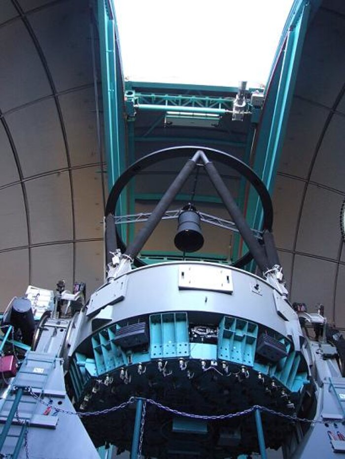 SOAR telescope viewed from the dome floor level. Three folded Cassegrain side ports (light grey rectabgular covers) are visible, available for lightweight instruments that may be installed in the future.